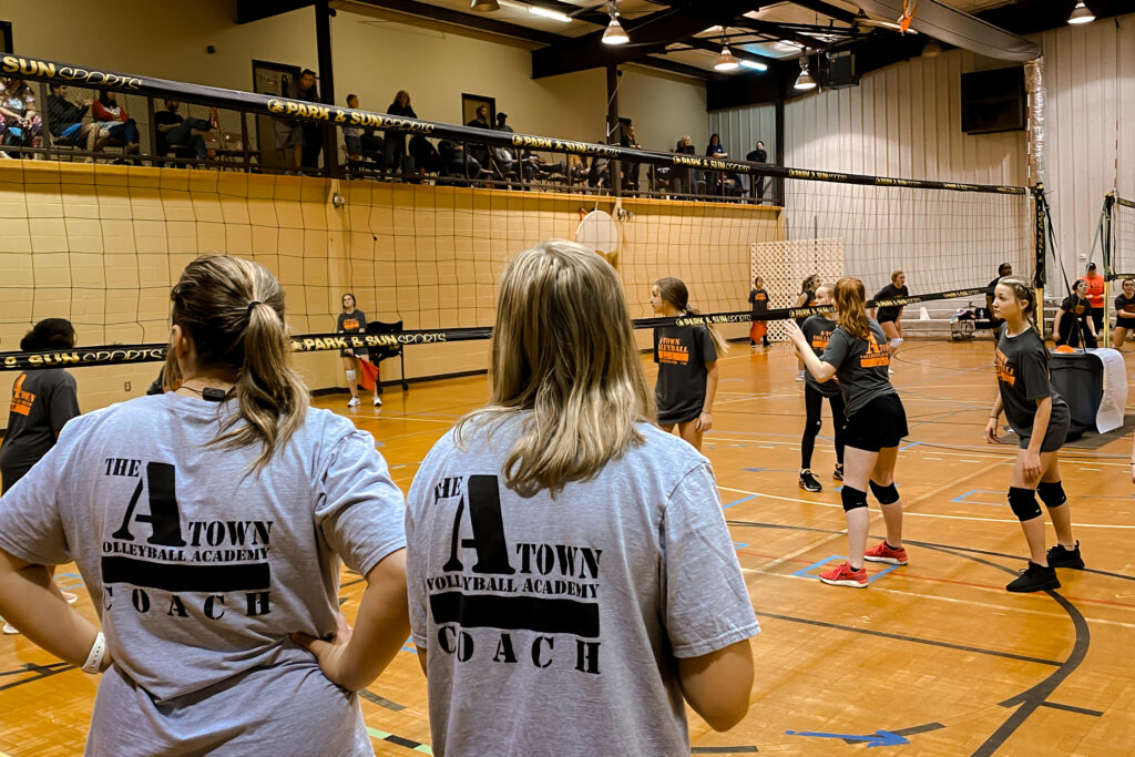 backs of two coaches with players in background